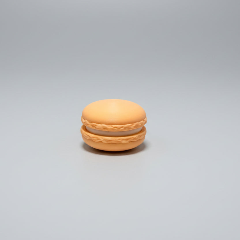 Orange Macaron toy on a grey surface