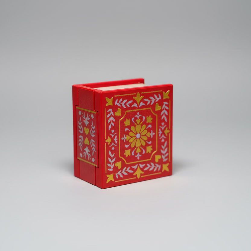 Red 3d printed box with decorative patterns on a wooden surface