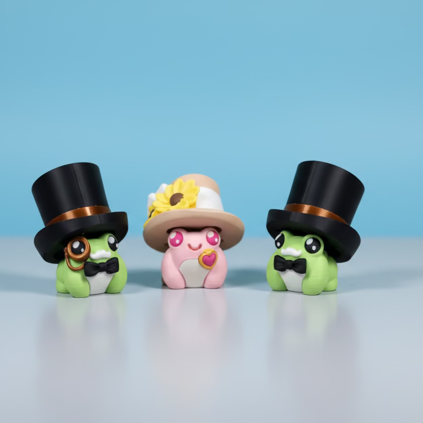 Three small figurines with top hats on a grey surface with a green background