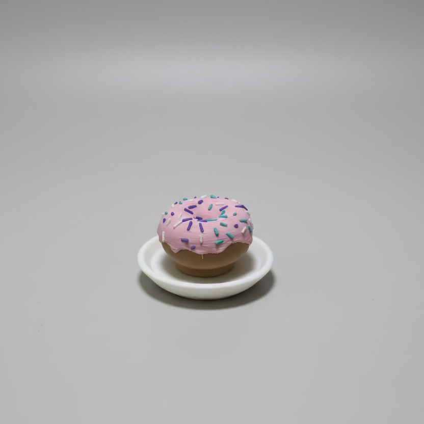 Pink donut with sprinkles on a white plate on a grey surface
