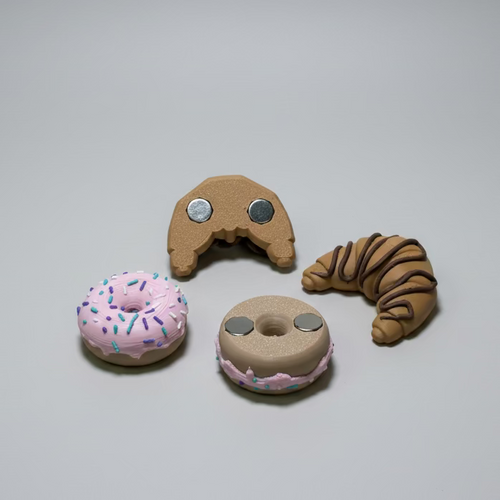 Toy doughnut and croissant on a grey surface