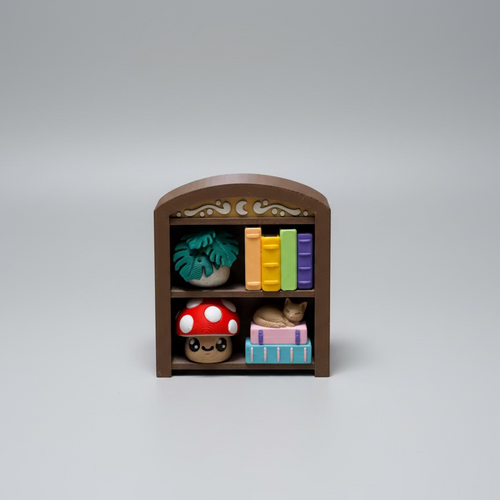 Plastic toy bookshelf with colorful books and items on a grey surface