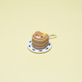 Small pancake stack toy with a bear design on a yellow surface