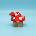 Red mushroom-shaped toy on a blue surface