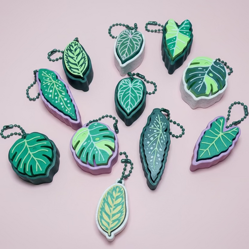 Leaf-shaped keychains on a pink surface