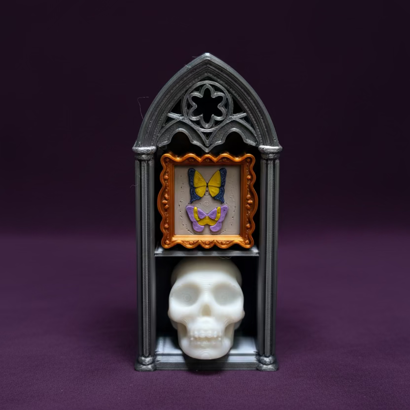 Small black gothic-style cabinet with a skull and butterfly on a wooden surface