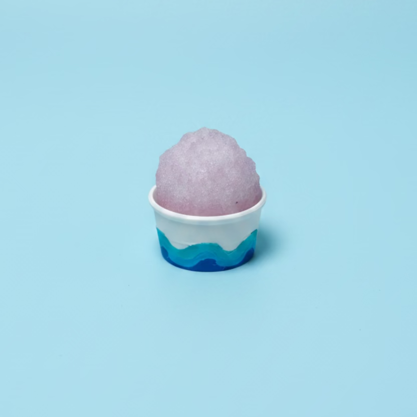 Purple shaved ice in a white cup on a wooden surface